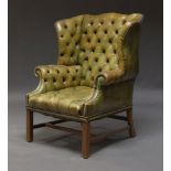 A George III style button back wing armchair, early to mid 20th Century, with green leather