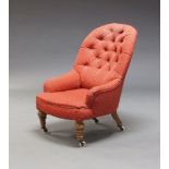 A Victorian button back nursing chair, upholstered in red fabric, on turned front legs with