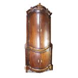 A monumental North German carved mahogany corner cupboard, third quarter 18th Century, of bow