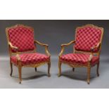 A pair of Louis XV style carved walnut fauteuils, early 20th Century, each with cartouche shaped