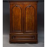 A Victorian mahogany linen press, the moulded cornice above two arch panelled doors, enclosing