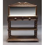 An Edwardian carved oak buffet, the raised mirrored back with carved scrolling foliate cresting,