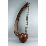 An lyre form stringed instrument, possibly of African origin, 20th century, with a gourd form