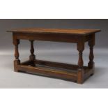 An oak refectory table, early to mid 20th Century, the metal bound three plank top, on baluster