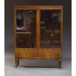 A French walnut vitrine bookcase, with applied blind fret carved frieze, above two glazed doors,