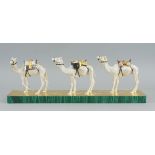 A gilt and silvered metal model of a camel train, of recent manufacture, each beast loaded with a