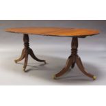 A George III style mahogany twin pedestal dining table, early 20th Century, with rounded ends and
