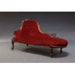 A Victorian chaise longue, the shaped back with carved scrolling decoration, upholstered in red