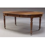 An Edwardian mahogany wind out dining table, with d-ends and two additional leaves, raised on