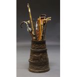 An oak stick stand, late 19th/early 20th century, of coopered construction, carved with friezes of