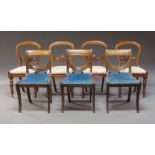 A set of four Victorian balloon back dining chairs, the splat with carved cabochon and scrolling