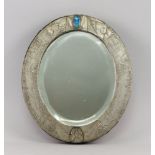 A Liberty style pewter mirror, of oval shape, the frame incised with leaves and stylised lotus buds,
