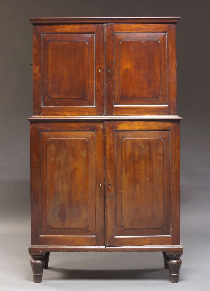 A Victorian mahogany campaign cabinet, the moulded cornice above two panelled cupboard doors,