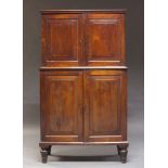 A Victorian mahogany campaign cabinet, the moulded cornice above two panelled cupboard doors,