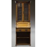 An Arts and Crafts oak bureau bookcase, early 20th Century, the breakfront cornice above two