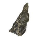 An Inuit grey soapstone sculpture of a male hunter, late 20th century, carved wearing a hood and