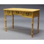 A modern bamboo desk, of recent manufacture, the rectangular top above three frieze drawers, on four