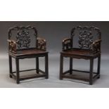 A pair of Chinese hardwood armchairs, mid 20th Century, the pierced backrests carved with birds