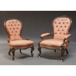 A pair of Victorian walnut and carved lady's and gentleman's chairs, with overall carved foliate