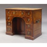 A Regency mahogany and line inlaid kneehole desk, the rectangular top above an arrangement of nine