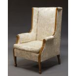 An Edwardian mahogany and line inlaid wingback armchair, with floral upholstery and loose seat