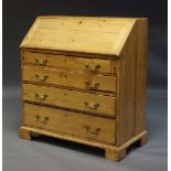 A George III pine bureau, the fall enclosing pigeon holes and three drawers, above four long