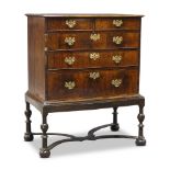 A Queen Anne walnut chest on stand, the feather banded top, above two short over three long