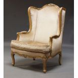 A wingback armchair, in the Louis XV taste, second half 20th Century, the curved crest rail with