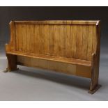 A pine church pew, first half 20th Century, with high slatted back on shaped end supports, 119cm
