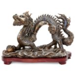 A Chinese porcelain model of a dragon, 20th century, striding forward on a base of waves, with