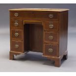 An Edwardian mahogany and crossbanded kneehole desk, the rectangular top, above an arrangement eight
