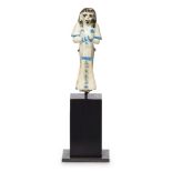 An Egyptian-style bichrome glazed faience shabti wearing a wig, details in turquoise, with single