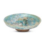 A Kashan turquoise-glazed pottery dish with moulded bull, Iran, 12th century, on a short foot,