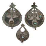 Three Seljuq turquoise-set and nielloed silver pendants, Iran, 12th century, each of drop form