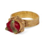 An ancient gold ring with red and green glass stone, ring size O approx., 3.5cm. high, weight 7.3gr.