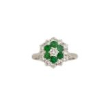 An emerald and diamond cluster ring, the brilliant-cut diamond centre to a circular-cut emerald