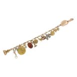 A late 19th / early 20th century gold charm bracelet, charms include: a pendant-mounted Egyptian