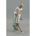 A Lladro porcelain figure of Gandhi, late 20th century, modelled with a book and staff in his hands,