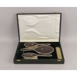 A cased silver and tortoiseshell-backed four-piece dressing table set, by Mappin & Webb,