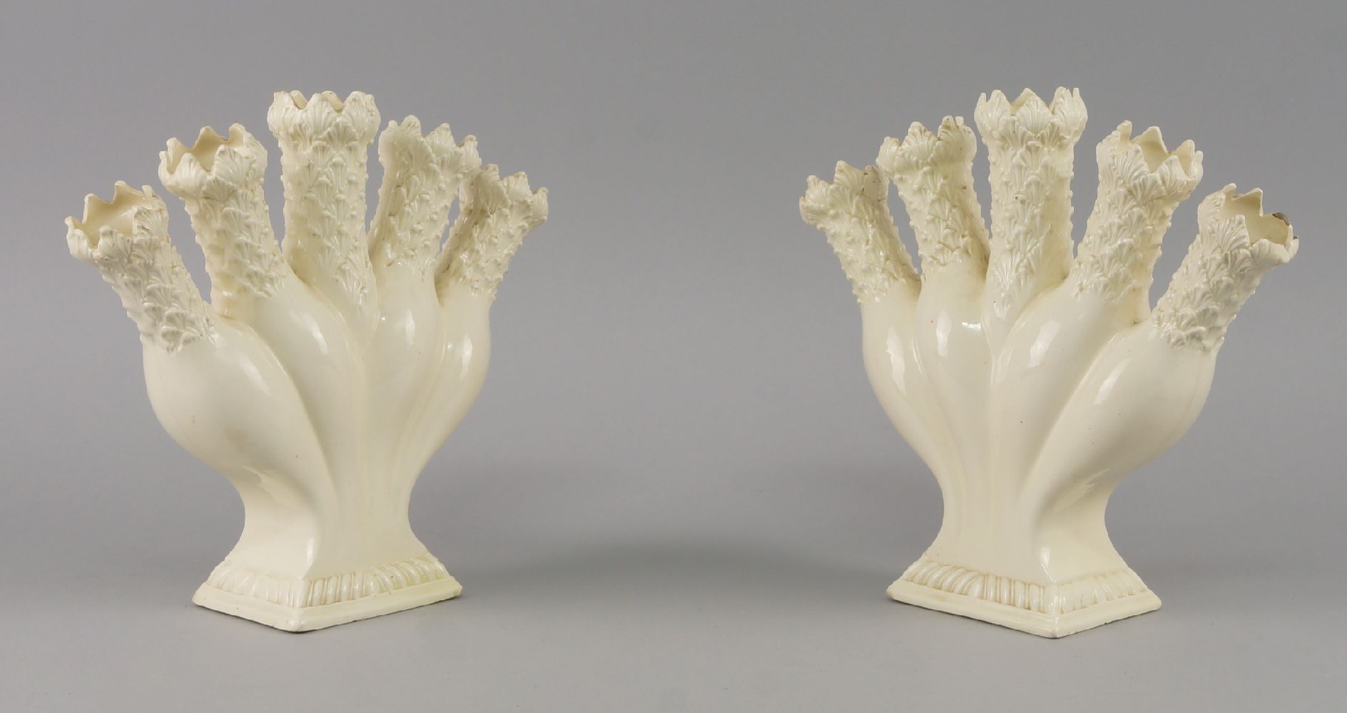 A pair of English creamware quintal flower vases, circa 1800, modelled to the rims with petal forms,