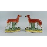 A pair of Staffordshire greyhounds, 19th century, modelled standing on oval naturally modelled bases