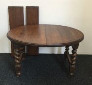 An early 20th century two leaf oak barley twist dining table