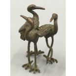 A bronze figure of three cranes
