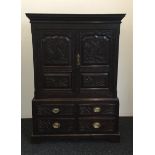 A Georgian carved oak cupboard over drawers