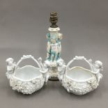 A pair of Continental porcelain baskets with applied cherubs and flowers,