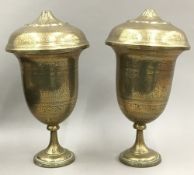 A pair of engraved Indian brass lidded vases