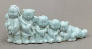 A Chinese porcelain brush rest formed as five boys