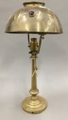 An Art Nouveau brass table lamp and a hinged brass wall light