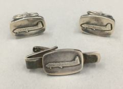 A pair of silver cufflink's decorated with an aeroplane,