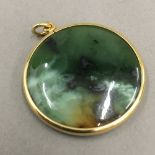 An 18 ct gold framed greenstone pendant (11 grammes total weight)